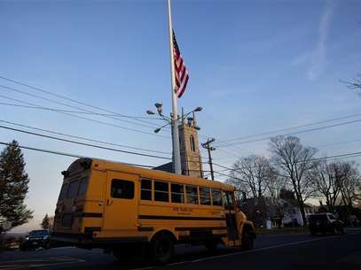 A flag is seen at half mast as a school bus passes along Main Street in Newtown, Connecticut December 14, 2012. Foto: Shannon Stapleton / Reuters