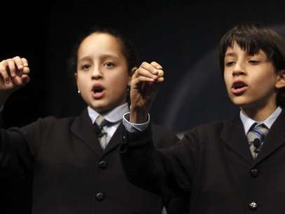 Los niños de San Ildefonso, Ismael Rastrelli y Sherley Fonseca, muestran el número 76.058 que ha sido agraciado con el premio Gordo, de 4 millones cada serie, en el Sorteo Extraordinario de Navidad que este año se celebra en el Teatro Real de Madrid. Foto: EFE en español