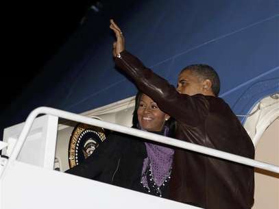U.S. President Barack Obama waves next to first lady Michelle Obama as they prepare to depart Joint Base Andrews outside Washington, for their holiday trip to Hawaii, December 21, 2012. Foto: Larry Downing / Reuters