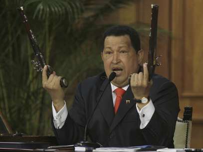 El presidente Hugo Chávez sostiene un par de pistolas que afirma pertenecieron al héroe de la independencia venezolana Simón Bolivar durante una ceremonia por el 229 aniversario del nacimiento del prócer efectuada en el palacio de Miraflores, en Caracas, en esta fotografía de archivo del 24 de julio de 2012.  Foto: Fernando Llano / AP