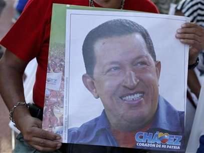 A supporter of Venezuelan President Hugo Chavez holds a picture of him, as she attends a mass to pray for Chavez's health in Caracas December 24, 2012. Foto: Carlos Garcia Rawlins / Reuters