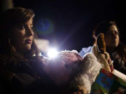 A woman holds stuff animals and Christmas presents at a memorial for the Sandy Hook Elementary School shooting victims in Newtown, Connecticut December 20, 2012. Foto: Joshua Lott / Reuters