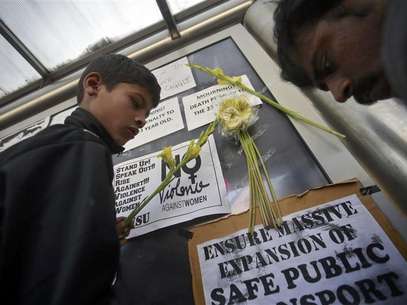 Demonstrators put flowers on the billboard of a bus stop during a protest march in New Delhi December 29, 2012. Foto: Danish Siddiqui / Reuters