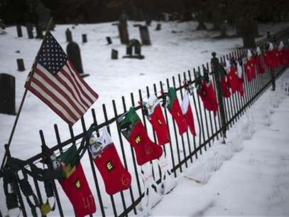 A U.S. flag hangs over stockings left as a memorial for victims of the Sandy Hook Elementary School shooting, along a fence surrounding the Sandy Hook Cemetery in Newtown, Connecticut December 27, 2012. Foto: Adrees Latif / Reuters