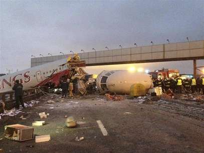 An aircraft wreckage lies next to a highway near Moscow's Vnukovo Airport December 30, 2012. A Russian airliner flying without passengers broke into pieces after it slid off the runway and crashed onto a highway outside Moscow upon landing on Saturday, killing four of the eight crew on board and leaving smoking chunks of fuselage on the icy road. Foto: Mikhail Voskresensky / Reuters