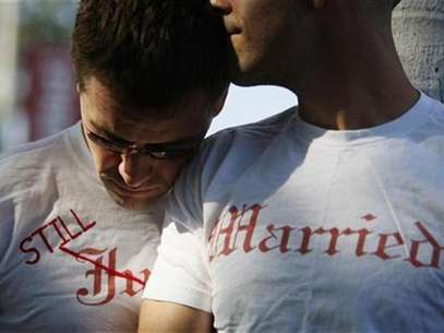 Gay couple Ethan Collings (L), 32, and his spouse Stephen Abate, 36, hug as they celebrate their one-year wedding anniversary in West Hollywood, California, June 16, 2009. Foto: Lucy Nicholson / Reuters