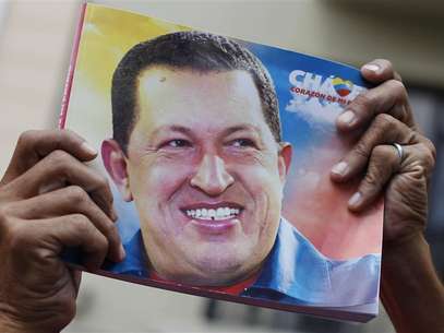 A Venezuelan man holds a picture of Venezuela's President Hugo Chavez during a mass to pray for his recovery at a church in Havana January 12, 2013. Foto: STRINGER / Reuters