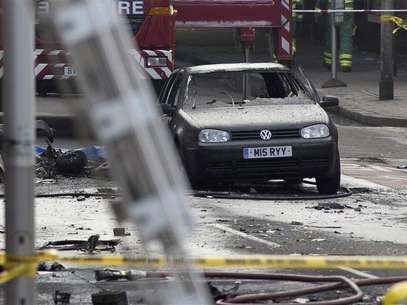 A damaged car is surrounded by debris from a crashed helicopter in Vauxhall, London January 16, 2013. Foto: Neil Hall / Reuters