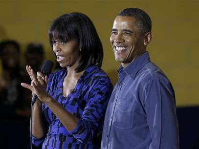 U.S. President Barack Obama smiles as first lady Michelle speaks to volunteers at Burrville Elementary School while participating in a day of service, hoping to encourage Americans to follow suit with volunteering projects nationwide in Washington January 19, 2013. Foto: Kevin Lamarque / Reuters