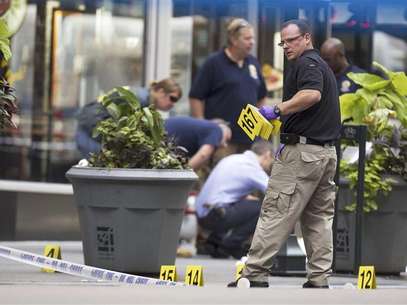 A New York Police Department officer places markers denoting spent shell casings in front of a sheet covering a body on 5th Ave after a shooting at the Empire State Building in New York in this August 24, 2012 photo. Foto: Lucas Jackson / Reuters