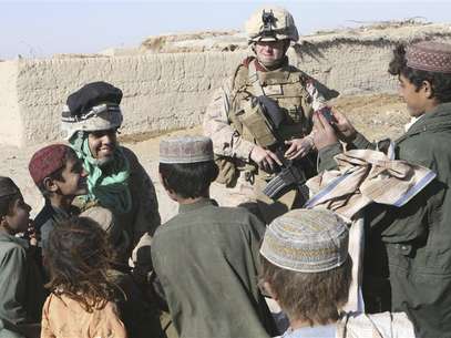2nd Lt. Carly E. Towers (R), the officer in charge of the female engagement team, 2nd Battalion, 2nd Marine Regiment, and Sahima Sheren, or Sam, an interpreter with the FET team, interact with children during a patrol through Tajik Khar in Garmsir, Afghanistan, in this December 18, 2009 U.S. Marine Corp handout photo. Foto: Dwight A / Reuters