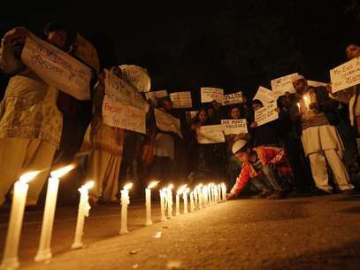A boy places a candle as demonstrators hold placards during a candlelight march for a gang rape victim, who was assaulted in New Delhi in this file photo taken January 16, 2013. Foto: Adnan Abidi / Reuters