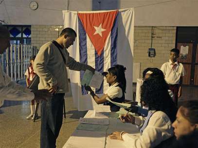 An election official gives a man ballot papers at a special polling station set up in Havana's main train station February 3, 2013. Cubans go to polls to elect National Assembly representatives. Foto: Desmond Boylan (CUBA - Tags: POLITICS ELECTIONS) / Reuters