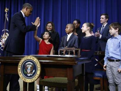 U.S. President Barack Obama high-fives eight-year-old Hinna Zejah after unveiling a series of gun control proposals during an event at the White House in Washington, January 16, 2013. Foto: Jason Reed / Reuters