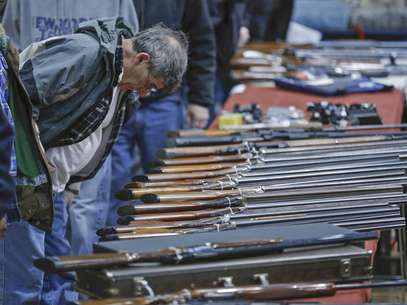 Un posible cliente observa escopetas durante una muestra de armas en el Centro de Convenciones Plaza Empire State en Albany, Nueva York, el 26 de enero de 2013. Cuatro senadores intentan alcanzar una solución negociada para ampliar el requisito sobre la verificación de los antecedentes a quienes quieran poseer un arma.  Foto: Philip Kamrass / AP