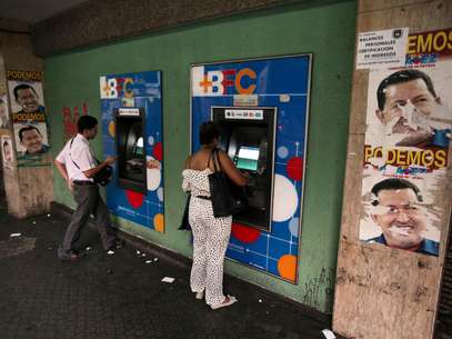 Propaganda electoral del presidente Hugo Chávez flanquea cajeros automáticos en Caracas, 8 de febrero de 2013. El lunes 11 de febrero de 2013 se cumplen dos meses desde la última aparición pública de Chávez, quien permanece en La Habana, Cuba, y se ahonda el misterio en torno a su estado de salud.Los boletines del gobierno abundan en frases optimistas, pero ofrecen escasa información concreta.   Foto: Fernando Llano / AP