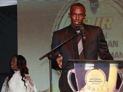 Jamaican Olympic sprinter Usain Bolt (R) speaks as Shelly-Ann Fraser-Pryce looks on after they were presented with the National Sportsman and Sportswoman of the Year awards, at the 52nd annual award ceremony in Kingston, January 11, 2013. Picture taken January 11, 2013. Foto: Gilbert Bellamy / Reuters