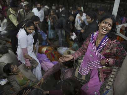 Una mujer llora mientras junto con otros miembros de su familia está cerca del cuerpo de un pariente que murió el domingo 10 de febrero de 2013 durante una estampida en un andén de la principal estación ferroviaria de la localidad india de Allahabad. Unas tres decenas de personas fallecieron cuando decenas de miles participantes en un festival religioso salieron en estampida, informaron autoridades.  Foto: Kevin Frayer / AP