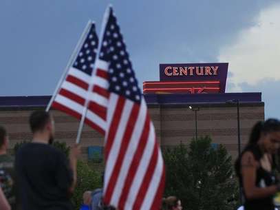 People stand on a hillside behind a memorial for victims behind the theater where a gunman opened fire last Friday on moviegoers in Aurora, Colorado July 22, 2012. Foto: Shannon Stapleton / Reuters