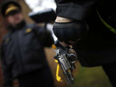 An Evanston police officer holds a firearm that was turned in as part of an amnesty-based gun buyback program in Evanston, Illinois December 15, 2012. Foto: Jim Young / Reuters