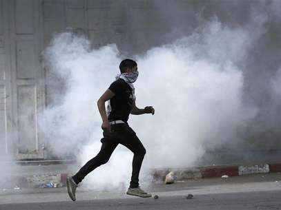 A Palestinian protester uses a sling shot to throw a stone at Israeli soldiers and border policemen during clashes at Hawara checkpoint near the West Bank city of Nablus February 24, 2013. Foto: Abed Omar Qusini / Reuters