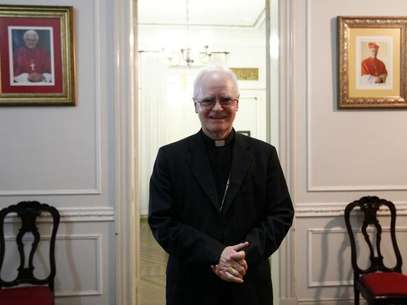 El cardenal brasileño Odilo Scherer voló esta semana a Roma para asistir al cónclave que elegirá al sucesor del Papa Benedicto XVI. Y sus fieles rezan para que no regrese. En la imagen, el arzobispo de Sao Paulo Odilo Scherer posa junto a fotografías del papa Benedicto XVI y sí mismo en Sao Paulo, el 19 de febrero de 2013. Foto: Nacho Doce / Reuters