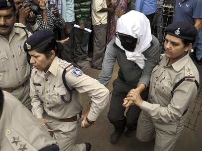 Policías acompañan a una mujer suiza a un examen médico en un hospital en Gwalior, en el estado de Madya Pradesh, el sábado 16 de marzo de 2013, después de que, según la policía, la violaran ocho individuos. Foto: AP