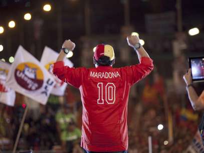 El ex astro del fútbol argentino Diego Armando Maradona saluda a la multitud durante el cierre de campaña del candidato oficialista a la presidencia de Venezuela, Nicolás Maduro en Caracas, Venezuela, el jueves 11 de abril de 2013.  Foto: Ramón Espinosa / AP