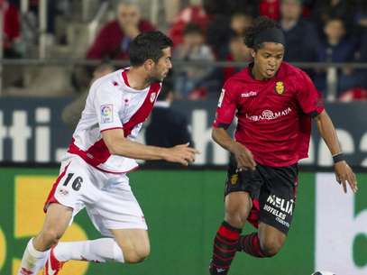 El delantero mejicano del RCD Mallorca Giovani Dos Santos (d), disputa el balón al defensa del Rayo Vallecano Jordi Amat durante el partido correspondiente a la trigésimo segunda jornada de Liga, disputado ante el RCD Mallorca esta noche en el Iberostar Estadio. Foto: EFE