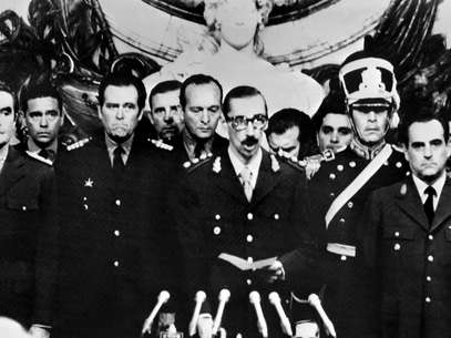 Imagem do dia 29 de março de 1976 mostra o general Jorge Videla (centro) prestando juramento como presidente da Argentina, após o golpe militar Foto: AFP