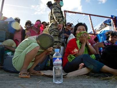 Pessoas fazem filas para receber ajuda no aeroporto de Tacloban Foto: AFP
