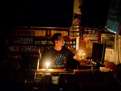 Comerciante trabalha à luz de velas durante blecaute em Buenos Aires Foto: AP