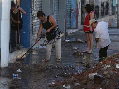 Comerciantes tentam limpar a calçada Foto: Marcos Bezerra / Futura Press