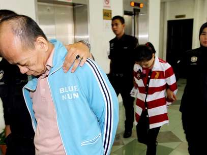 Polícia da Malásia escolta, em 6 de março, Fong Kong Meng, 58, e sua mulher Teoh Ching Yen, 56, após receberam sentença de morte em Shah Alam, arredores de Kuala Lumpur, por matar sua empregada doméstica de fome Foto: AFP