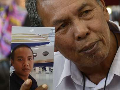 O pai de Mohd Selamat mostra a foto do filho que estava a bordo do avião desaparecido. A polícia do país investiga possível participação do engenheiro na mudança de rota do Boeing Foto: Reuters