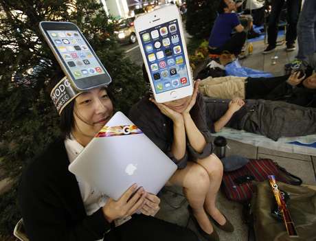 Com iPhones de papel, fãs da Apple aguardavam na fila, em Tóquio, no Japão, para conseguir comprar o smartphone Foto: Reuters