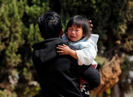 Uma menina chora no ombro de seu pai enquanto eles esperam para ser evacuados por uma equipe de resgate voluntário após os combates entre rebeldes e forças do governo, em Laukkai, em 17 fevereiro Foto: AP