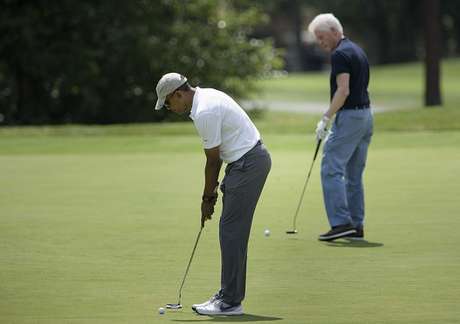 Brendan Smialowski / Getty Images Obama e Clinton jogam golfe nos EUA