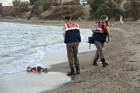 Policiais turcos fotografam o corpo do sírio Aylan Kurdi, de três anos, que morreu afogado após o naufrágio de uma embarcação de refugiados