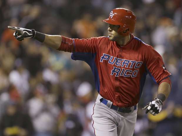 Alex R&iacute;os de Puerto Rico se&ntilde;ala hacia la cueva del equipo tras conectar un jonr&oacute;n de dos carreras contra Jap&oacute;n en la semifinal contra Jap&oacute;n en el Cl&aacute;sico Mundial de B&eacute;isbol el domingo 17 de marzo de 2013.  Foto: Eric Risberg / AP