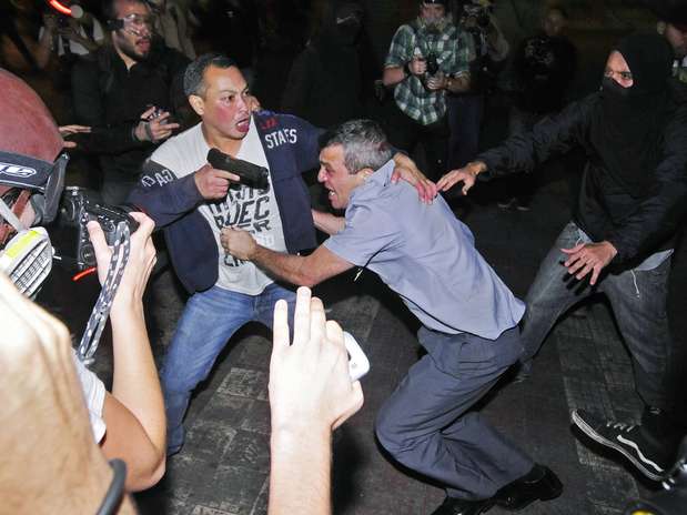 Soldado à paisana tenta proteger coronel de agressões; oficial teve a arma roubada, mas esta foi recuperada pelo seu motorista, segundo a PM Foto: Reuters