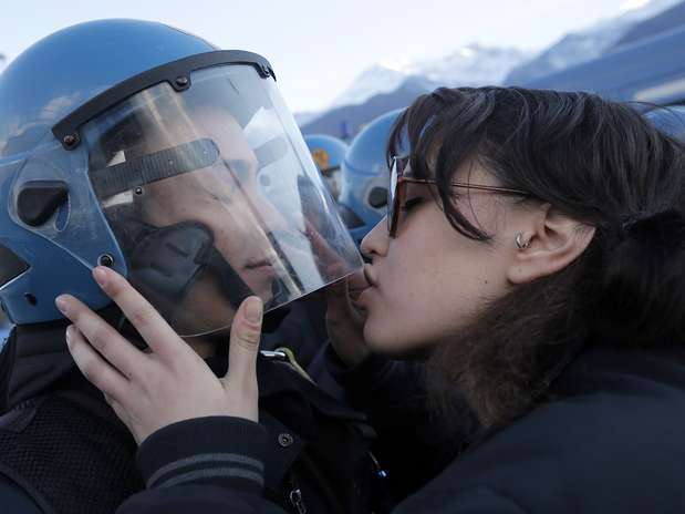 Manifestante beija policial durante protesto contra construção de linha de trem de alta velocidade em Susa, na Itália Foto: AFP