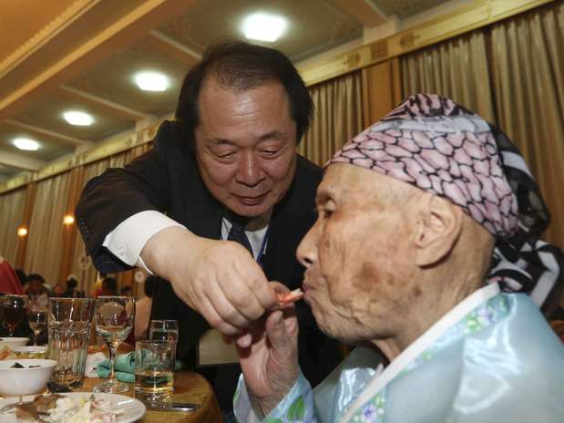 Sul-coreano ajuda a tia que vive no Norte durante o encontro de famílias desta sexta-feira Foto: Reuters