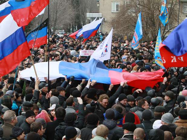Manifestantes pró-Rússia seguram bandeiras do país durante protesto no centro de Donetsk, na Ucrânia, neste sábado, 1 de março Foto: AP
