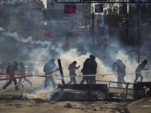 Manifestantes fogem de gás lacrimogêneo em Caracas Foto: EFE Manifestantes fogem de gás lacrimogêneo em Caracas Foto: EFE