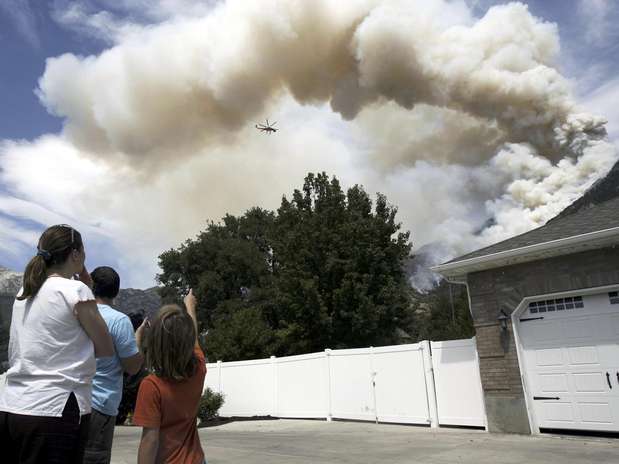 Emily y Byron Smith, y su hijo Ammon, de 9 años, observan a su regreso de la evacuación a las cuadrillas aéreas que siguen combatiendo un incendio forestal cercano a Alpine, Utah, el mièrcoles 4 de julio de 2012.  Foto: The Salt Lake Tribune, Francisco Kjolseth / AP