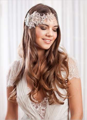 Look años 20. Con un pelo suelto marcado con algunas ondas muy naturales, cobra protagonismo un tocado muy del estilo años 20 con tul y flores, que da a la novia un aspecto muy romántico. Foto: Wedding chicks