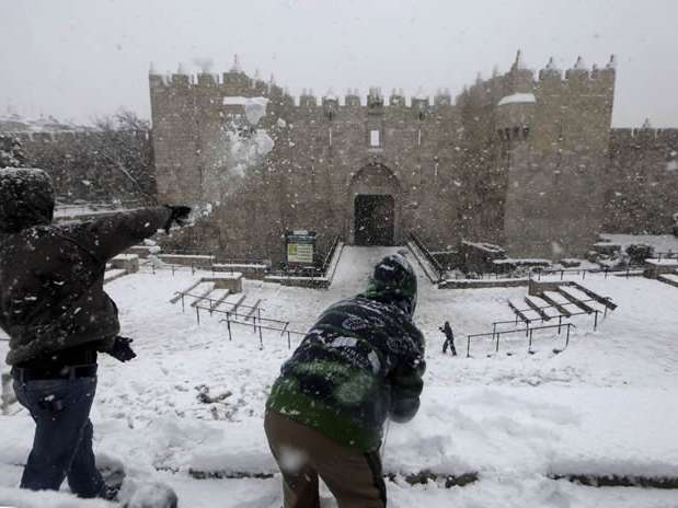 Niños palestinos juegan a tirarse bolas de nieve frente a la Puerta de Damasco en la vieja Jerusalén, en Israel, hoy, jueves 10 de enero de 2012. Oriente Medio sufre una ola de frío con fuertes nevadas en los últimos días.  Foto: EFE en español