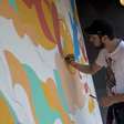Artista desenha mural para o público jovem do Planeta Terra