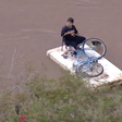 Menino improvisa embarcação para atravessar enchente no RS